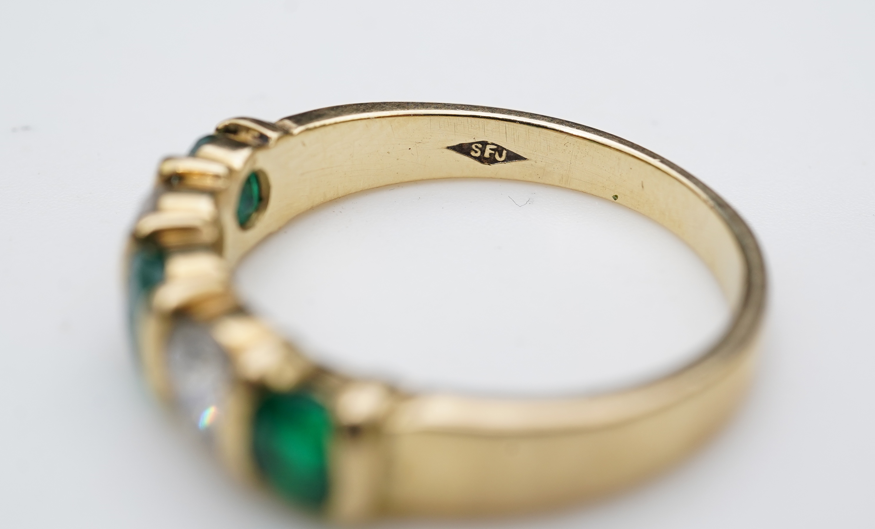 An emerald and diamond five-stone ring
